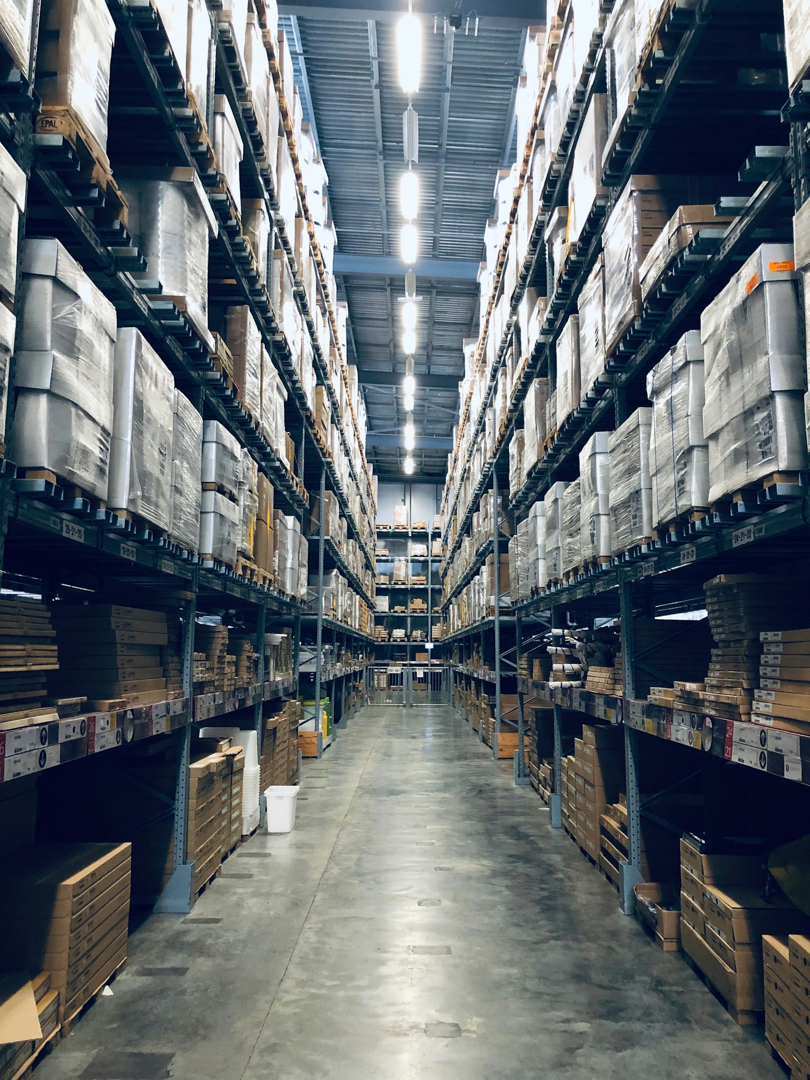 A long warehouse aisle lined with racked stock.