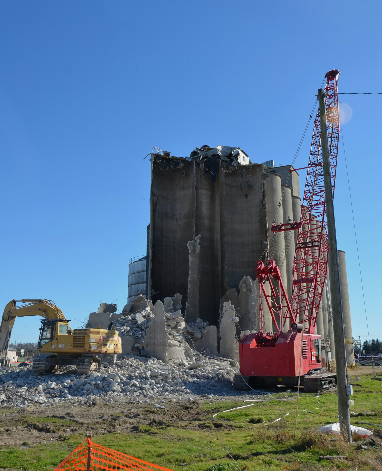 Excavators and a crane beside a concrete structure during demolition.