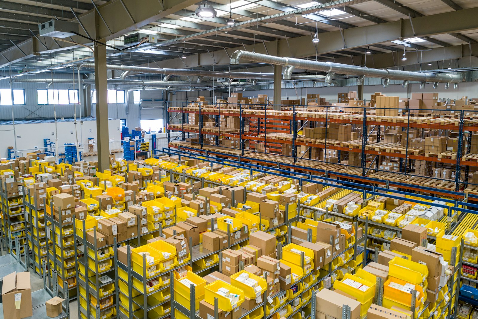 A distribution center floor filled with stacked crates and racking.