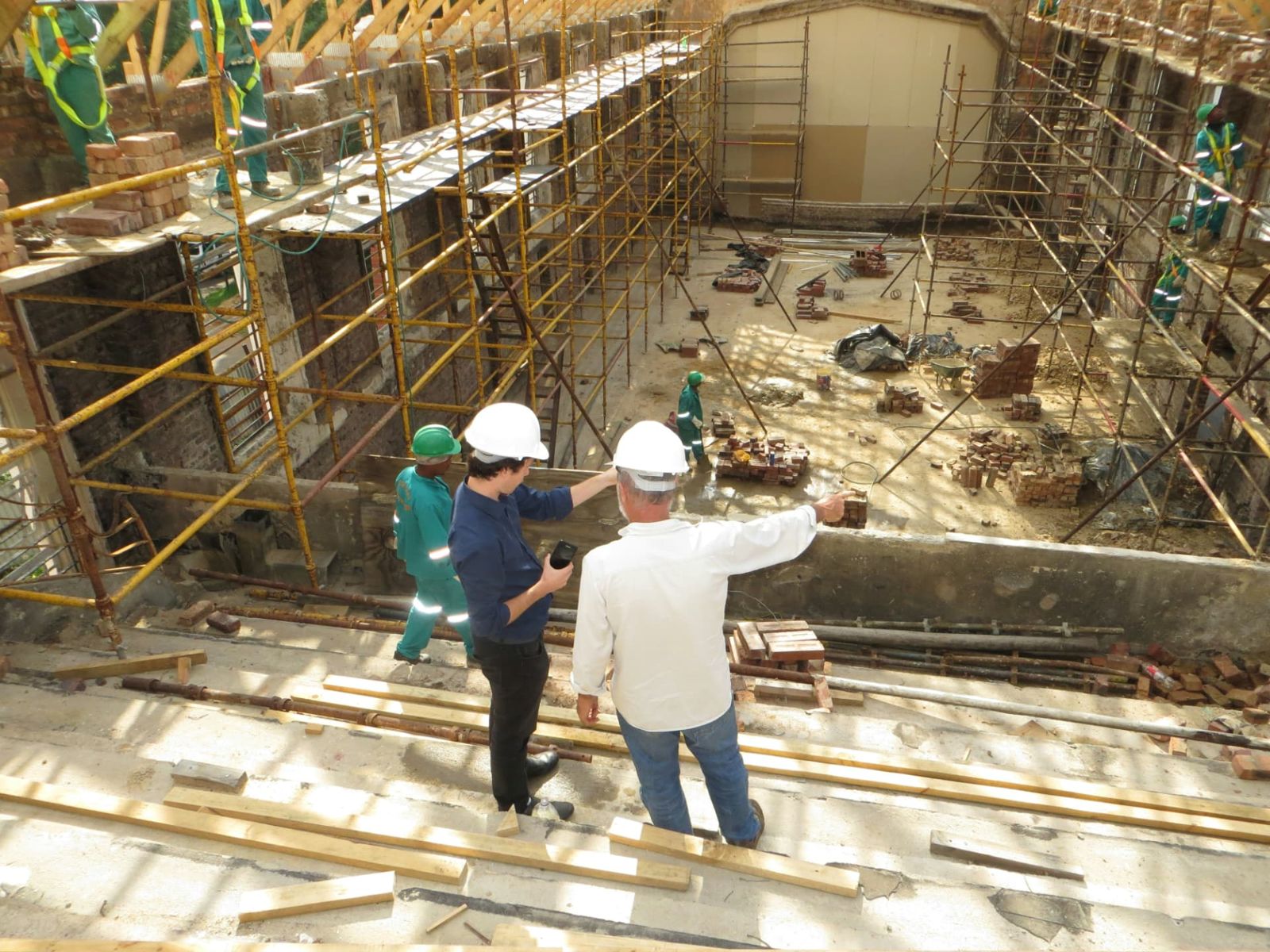 Site leads reviewing a work area surrounded by scaffolding.